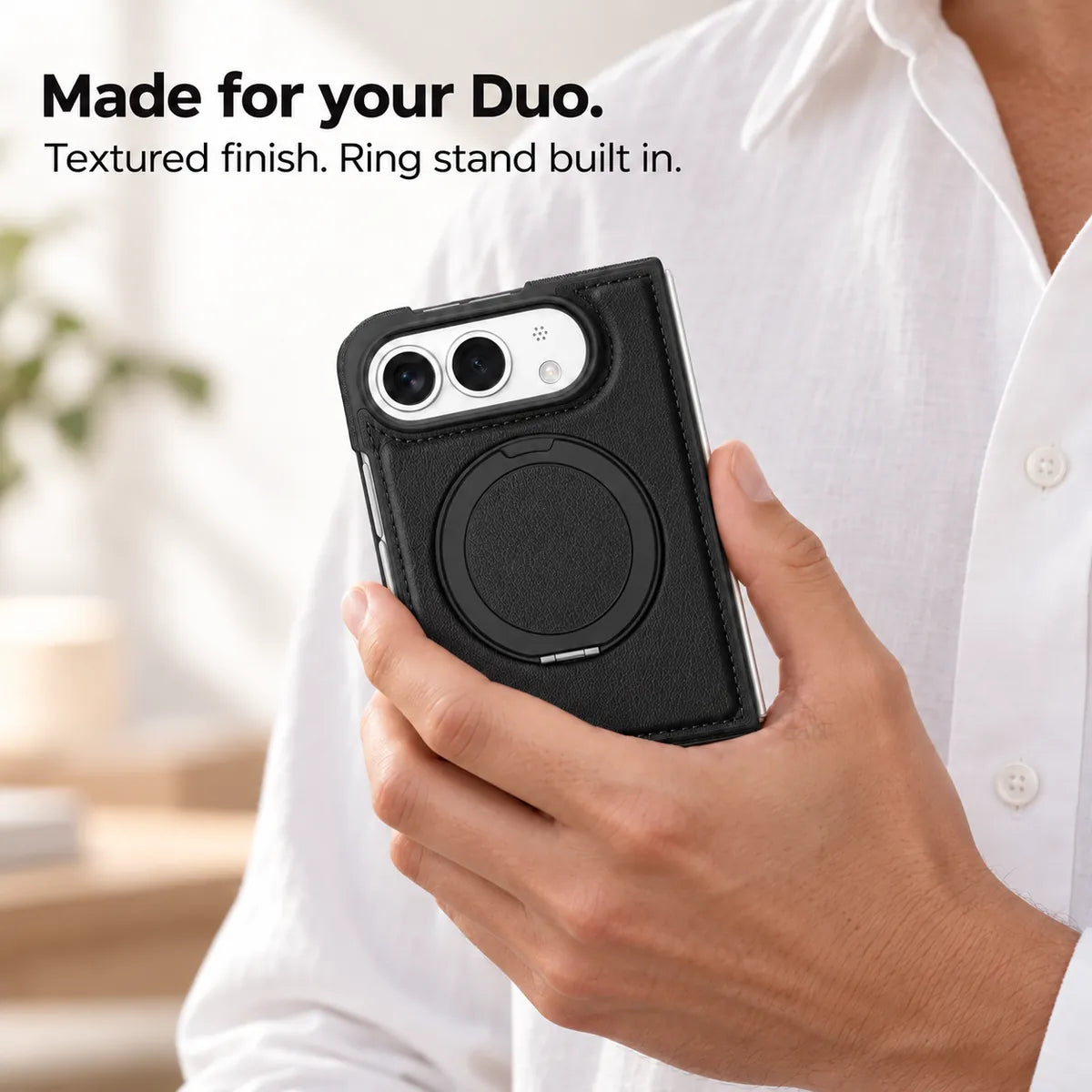 Hand holding a textured synthetic leather folding phone case with the ring stand folded flat. #color_Midnight Black