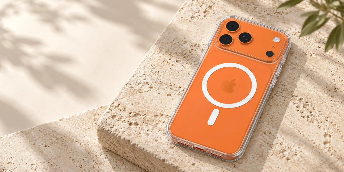 Clear magnetic phone case on an orange phone resting on a pale stone desk.