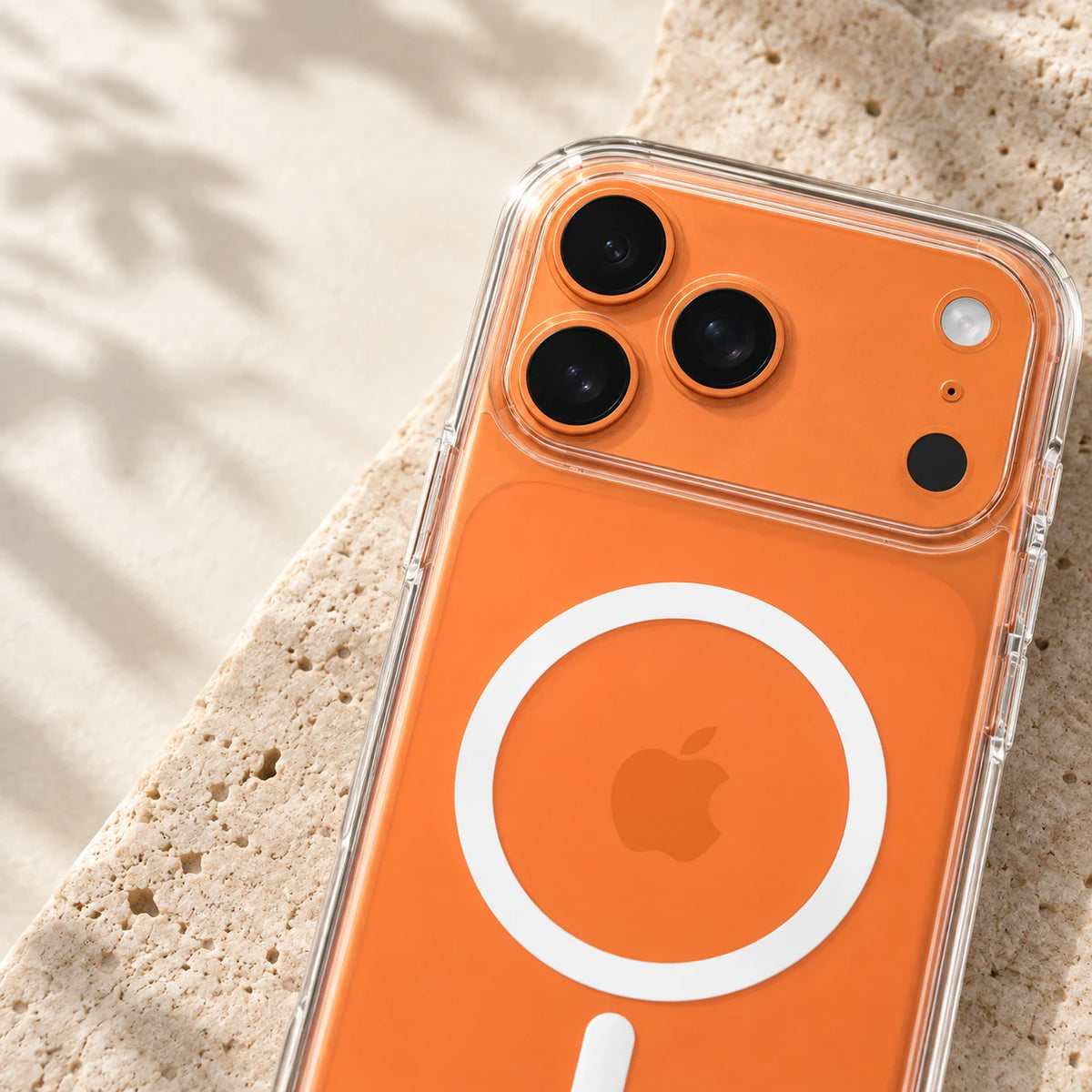 Close-up of the transparent raised camera rim around three lenses on an orange phone.